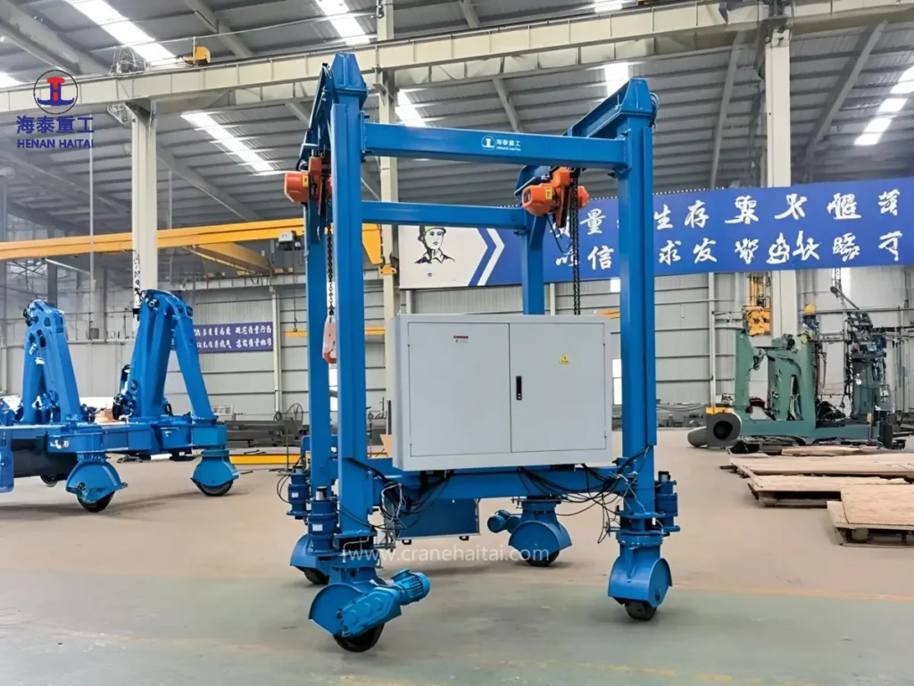 Haitai compact electric rubber-wheeled gantry crane with electric chain hoists, control cabinet and motor-driven wheels in an assembly workshop