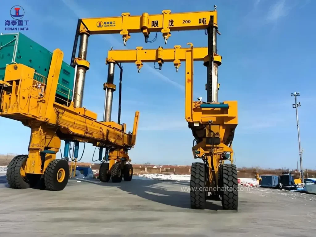 Haitai hydraulic rubber-tyred lifting gantry with large hydraulic cylinders and heavy-duty tyres, marked with a 200-ton load limit